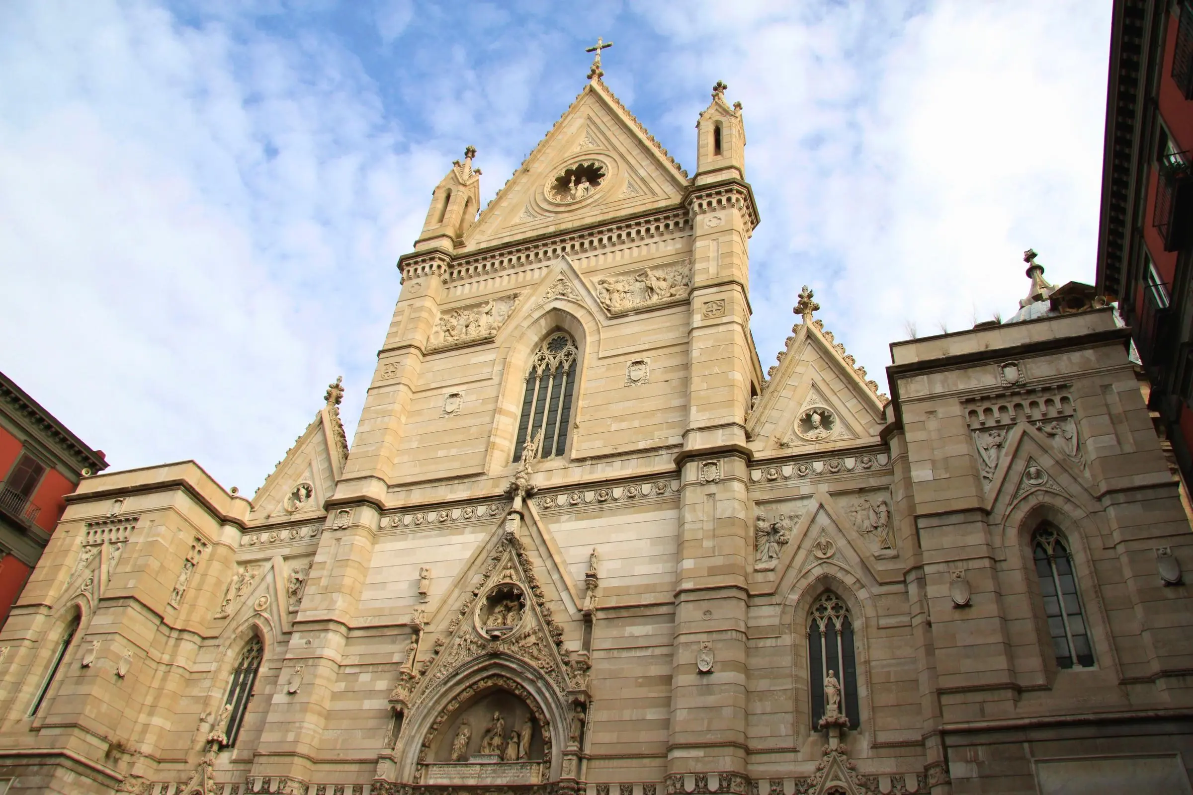 The Neo-Gothic facade of Naples Cathedral dominating a small piazza