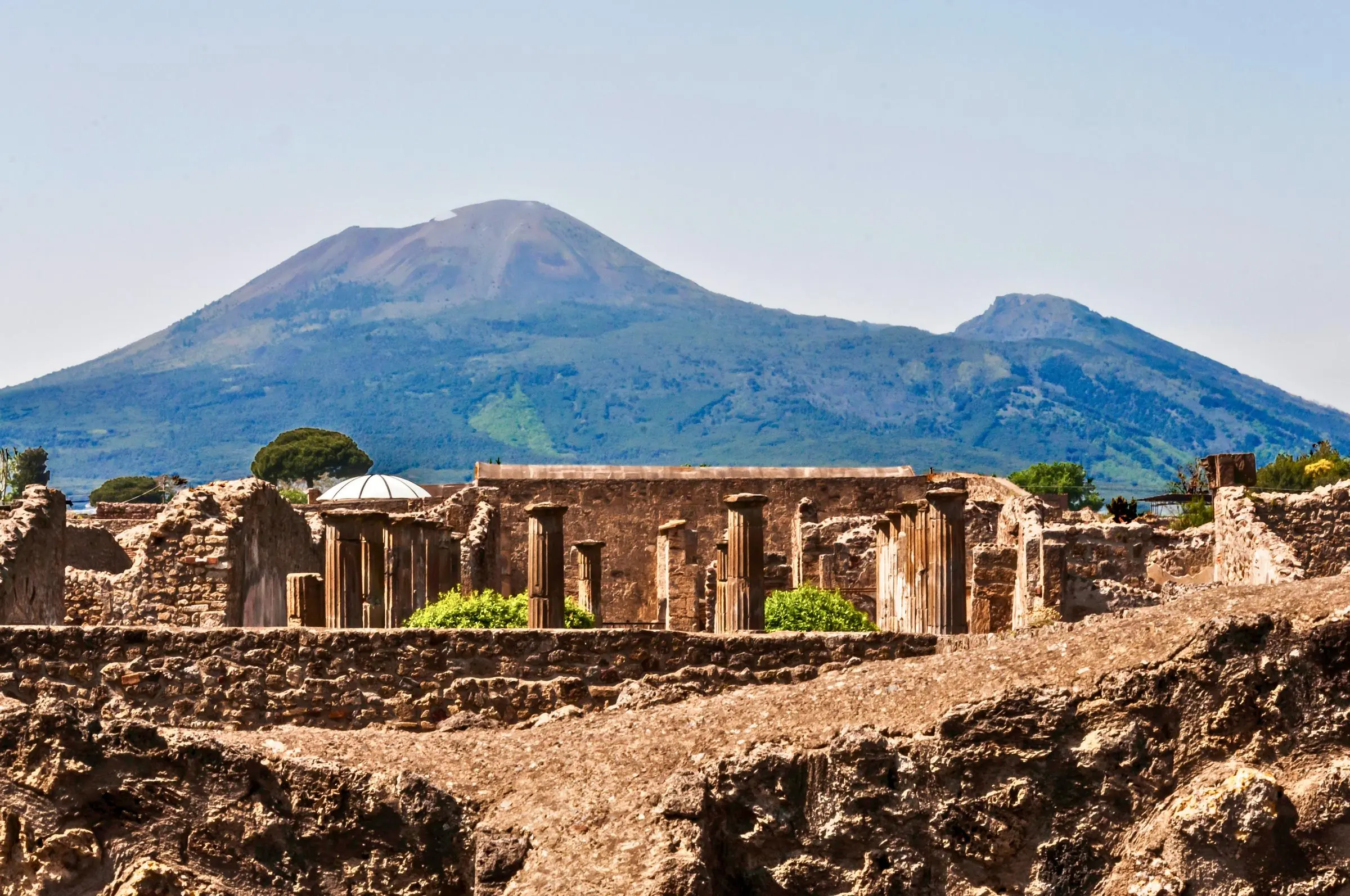 The ancient ruins of the Pompeii Forum with Mount Vesuvius looming in the background